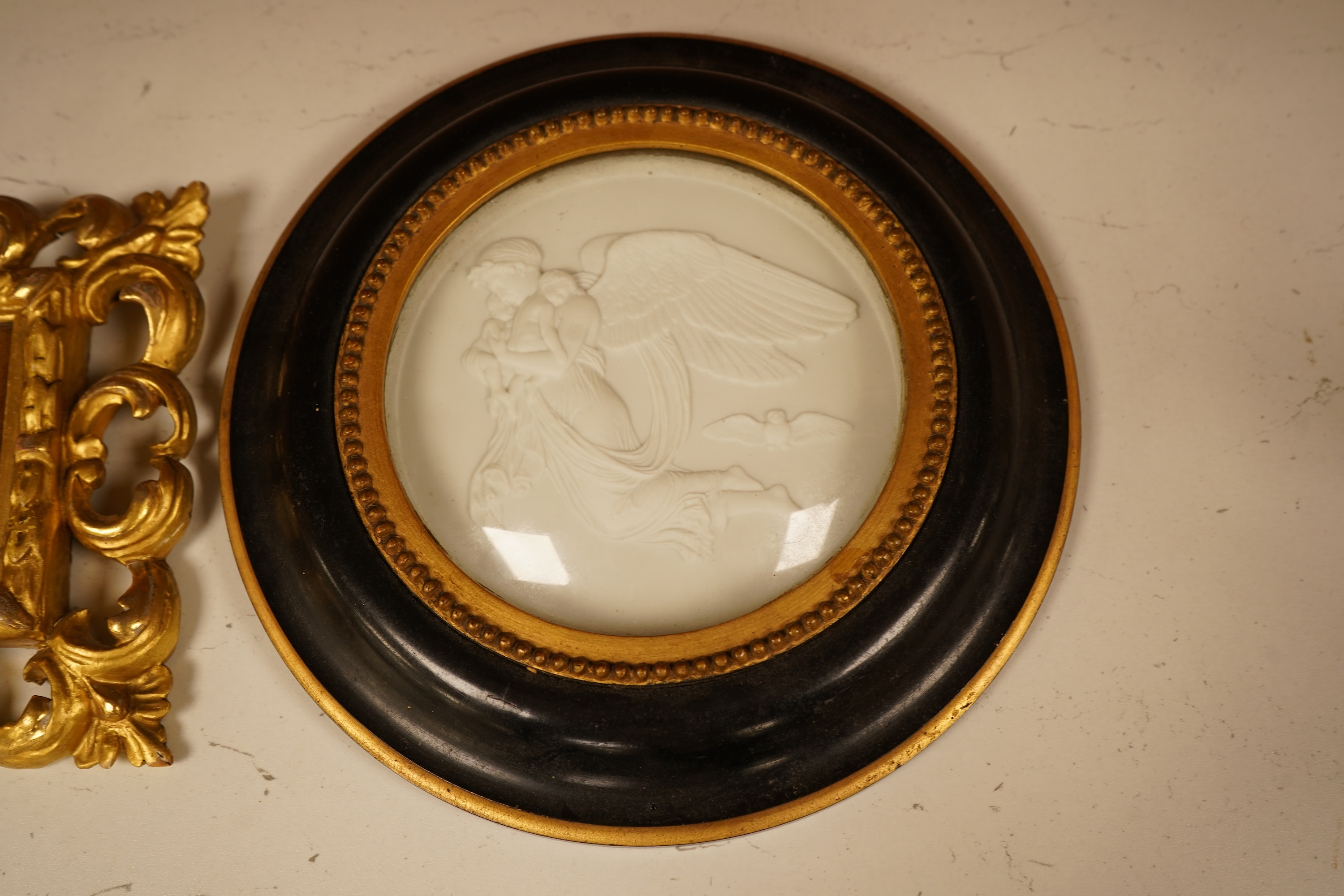 A late 19th century mother of pearl plaque of a saint, housed in a gilt wood florentine frame, together with a pair of Copenhagen biscuit porcelain plaques of Night and Day after Thorvaldsen, in convex frames